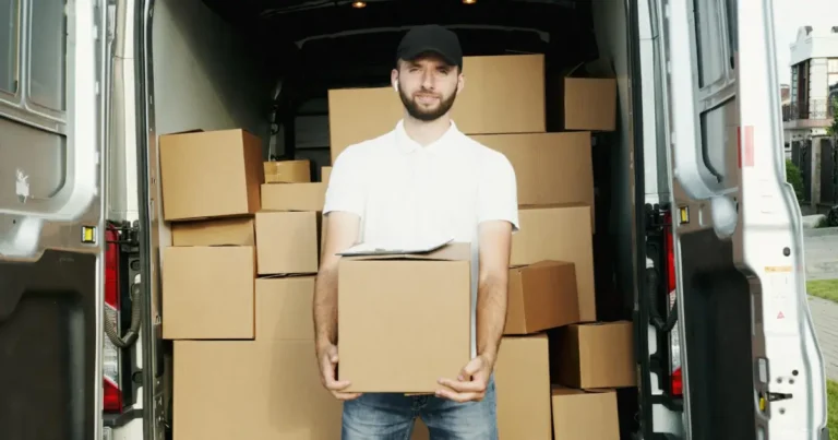 Homem segurando uma caixa com uma van de entregas ao fundo representando a logistica em loja de varejo